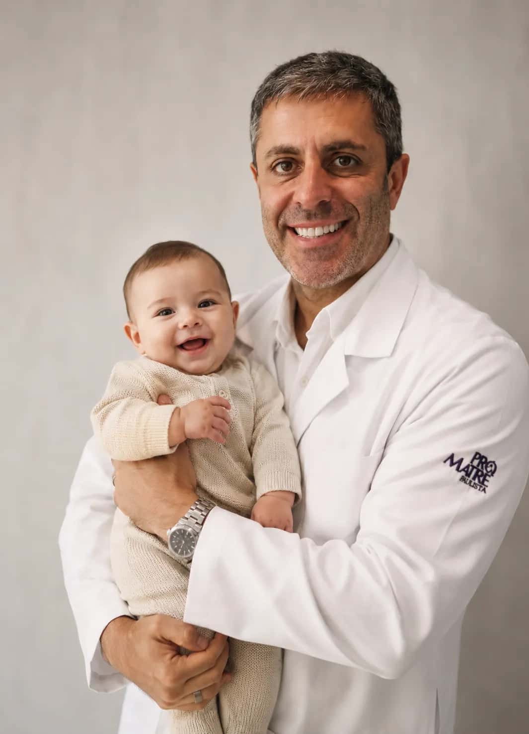 Dr. Márcio Jordão Napoli segurando um bebê recém-nascido